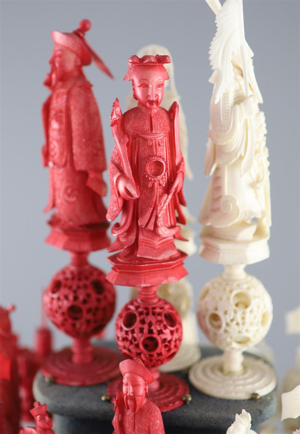 A set of 19th century Cantonese carved and red stained ivory chess pieces under dome, white king 20cm high